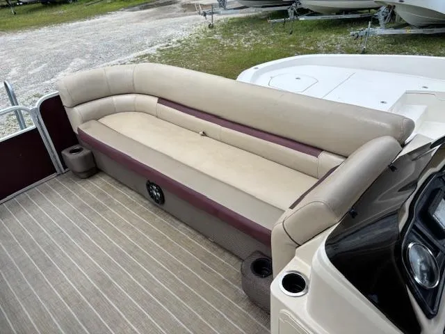 Slide: The Image of 2021 Sweetwater 2186 boat interior with beige and maroon seating, cup holders, and striped flooring. - 10