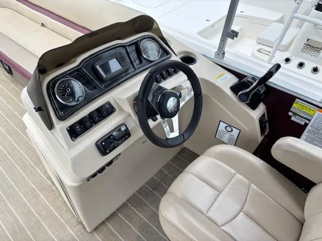Slide: The Image of Steering console of a 2021 Sweetwater 2186 boat with beige seating and controls. - 14