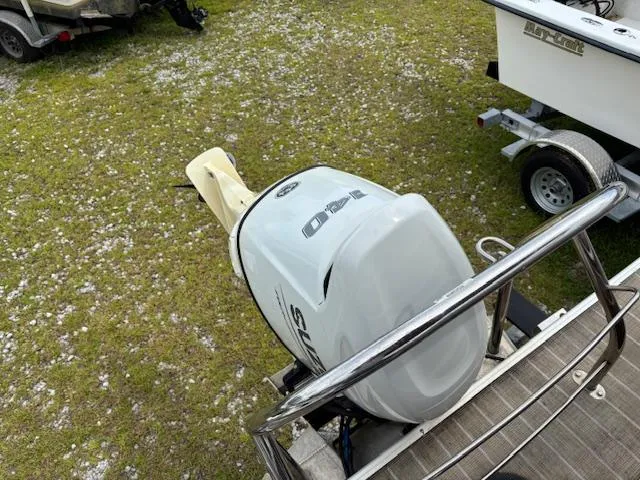 Slide: The Image of Outboard motor on Sweetwater 2186 boat, 2021 model, parked on grassy area. - 18
