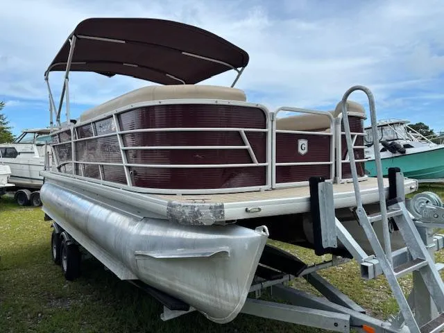 Slide: The Image of Pontoon boat on trailer, Sweetwater 2186, 2021 model, maroon and beige, parked outdoors. - 3