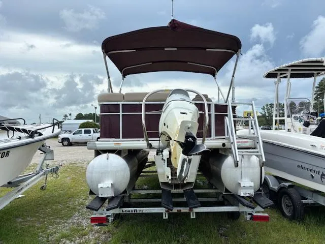 Slide: The Image of 2021 Sweetwater 2186 pontoon boat on trailer, parked outdoors under cloudy sky. - 5