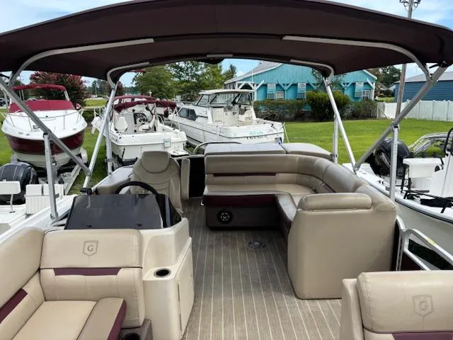 Slide: The Image of Sweetwater 2186 pontoon boat, 2021 model, with spacious seating and canopy, docked among other boats. - 8