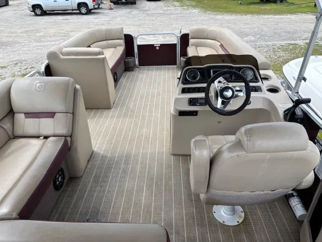 Slide: The Image of 2021 Sweetwater 2186 pontoon boat interior with beige seating and steering console. - 9