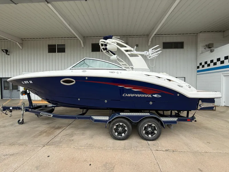 Slide: The Image of 2018 Chaparral 244 Sunesta Surf boat on trailer, parked under a covered area. - 1