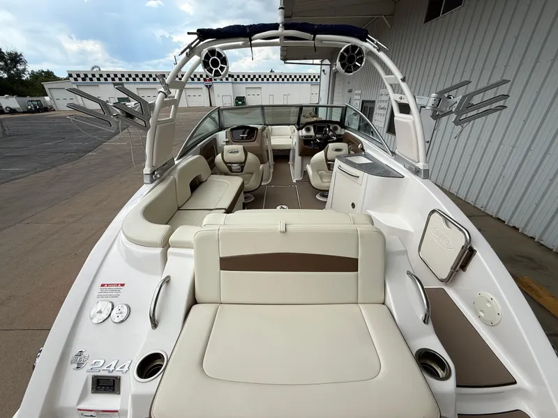 Slide: The Image of 2018 Chaparral 244 Sunesta Surf boat interior with seating and dashboard, docked outdoors. - 10