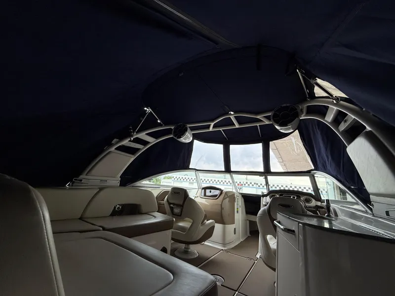 Slide: The Image of Interior of 2018 Chaparral 244 Sunesta Surf boat with seating and helm under canopy. - 24