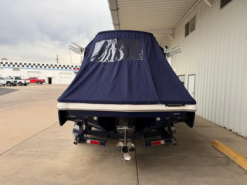 Slide: The Image of 2018 Chaparral 244 Sunesta Surf boat with blue cover, parked in a garage. - 30