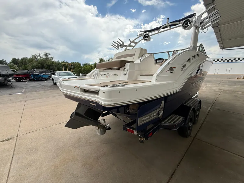 Slide: The Image of 2018 Chaparral 244 Sunesta Surf boat on trailer, parked outdoors under cloudy sky. - 5