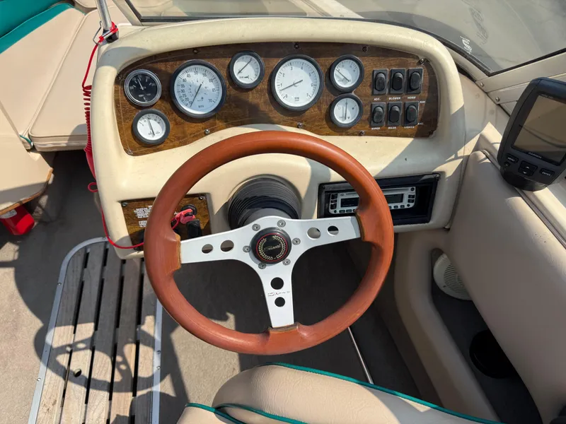 Slide: The Image of 1995 Seaswirl 201 boat dashboard with wooden steering wheel and instrument panel. - 11