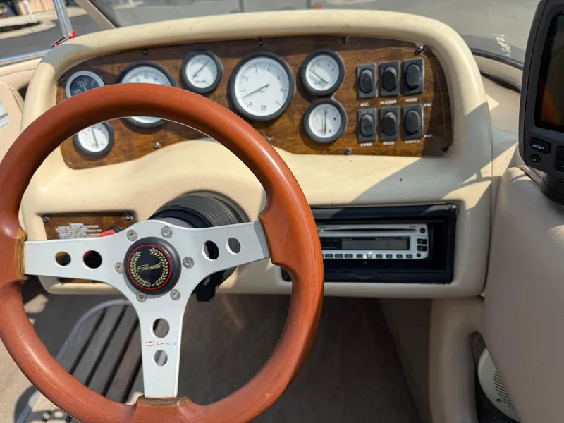 Slide: The Image of 1995 Seaswirl 201 boat dashboard with wooden steering wheel and instrument panel. - 13