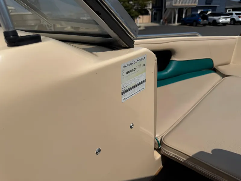 Slide: The Image of 1995 Seaswirl 201 boat interior with capacity label, beige and teal seating. - 14