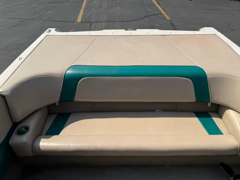 Slide: The Image of 1995 Seaswirl 201 boat interior with beige and green seating, parked on asphalt. - 16