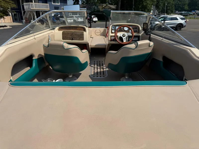 Slide: The Image of 1995 Seaswirl 201 boat interior with beige and teal seating, steering wheel, and dashboard. - 19