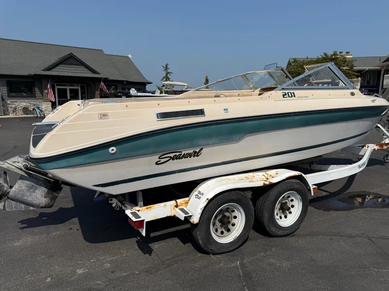 Slide: The Image of 1995 Seaswirl 201 boat on trailer, parked outside a building. - 2