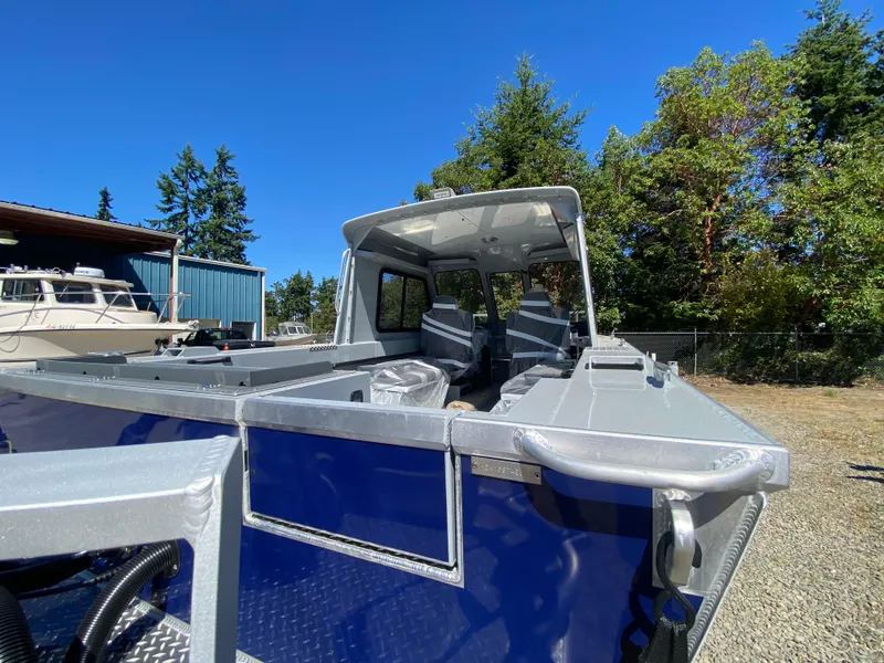 Slide: The Image of 2025 Hewescraft 190 Sea Runner HT boat, blue exterior, parked outdoors under clear sky. - 7