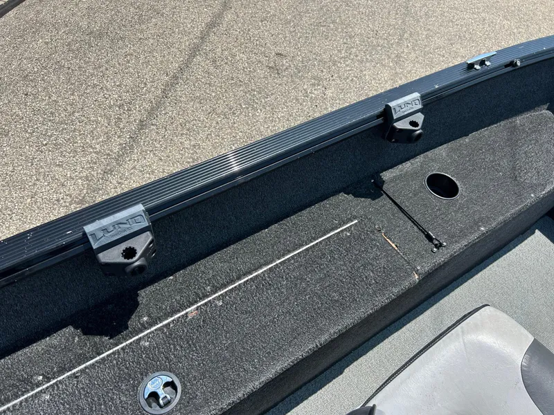 Slide: The Image of 2014 Lund 1625 Rebel XL SS boat interior with rod holders and carpeted deck. - 21