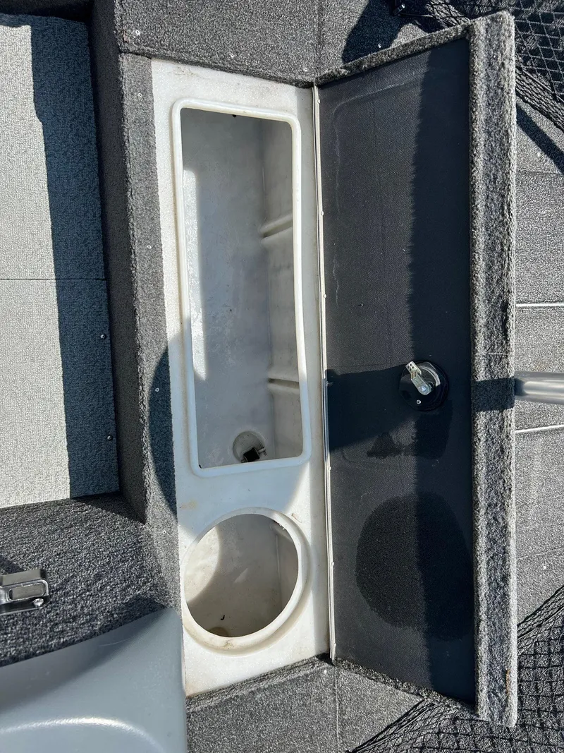 Slide: The Image of 2014 Lund 1625 Rebel XL SS boat storage compartment with open lid. - 25