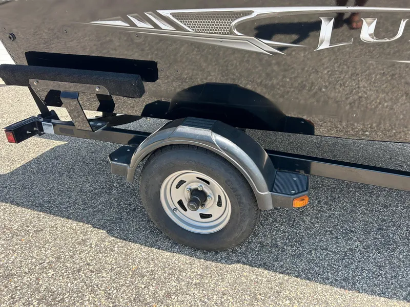 Slide: The Image of 2014 Lund 1625 Rebel XL SS boat trailer wheel on asphalt. - 31