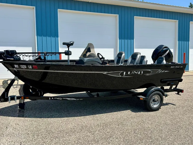 Slide: The Image of 2014 Lund 1625 Rebel XL SS boat on trailer, parked outside blue building. - 43