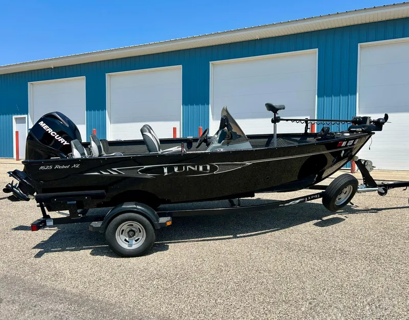 Slide: The Image of 2014 Lund 1625 Rebel XL SS boat on trailer, parked outside blue building. - 45