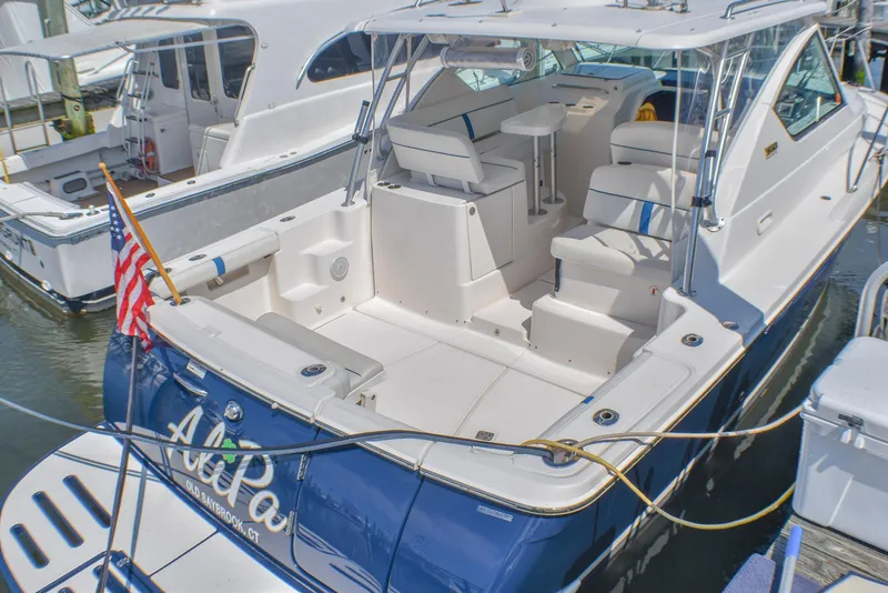 Slide: The Image of 2013 Tiara Yachts 3100 Open docked, featuring spacious seating and American flag. - 20