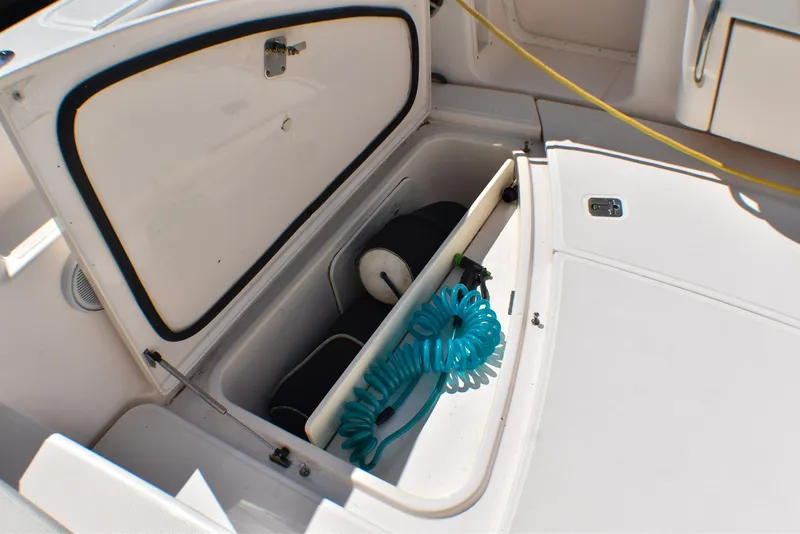 Slide: The Image of Open storage compartment on 2013 Tiara Yachts 3100 Open, featuring coiled blue hose. - 22