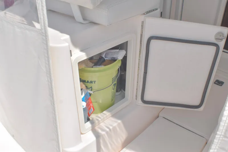 Slide: The Image of Storage compartment on a 2013 Tiara Yachts 3100 Open, containing cleaning supplies. - 23