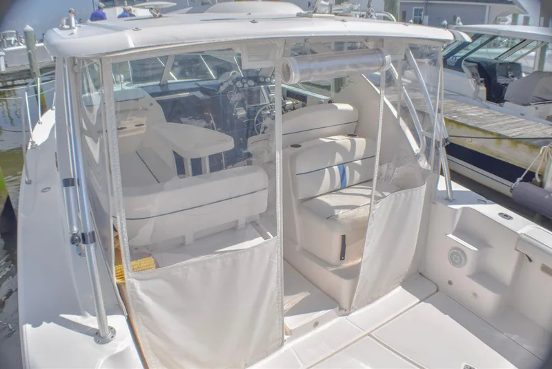 Slide: The Image of 2013 Tiara Yachts 3100 Open with enclosed cockpit and white seating at marina. - 25