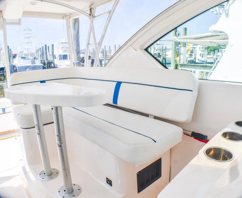 Slide: The Image of 2013 Tiara Yachts 3100 Open interior with white seating and table, docked at marina. - 26