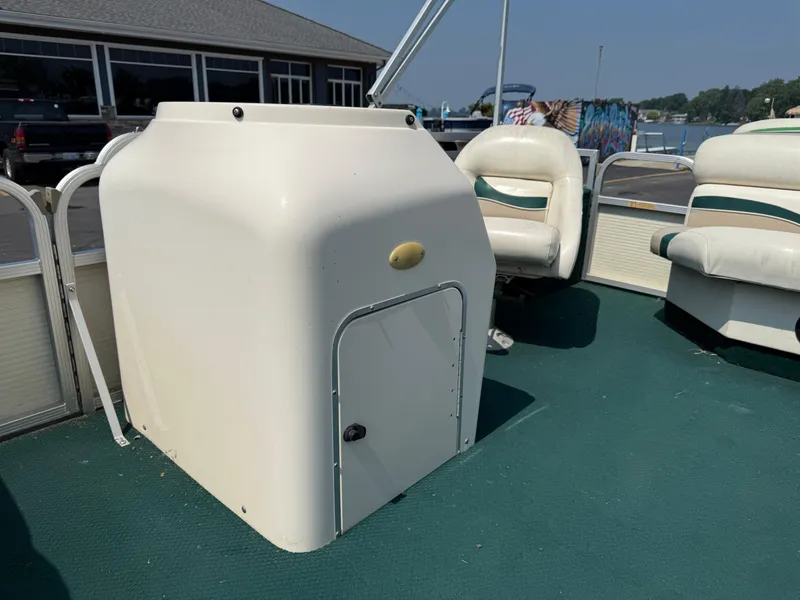 Slide: The Image of 1998 Bennington 22 boat interior with white seating and storage compartment. - 10