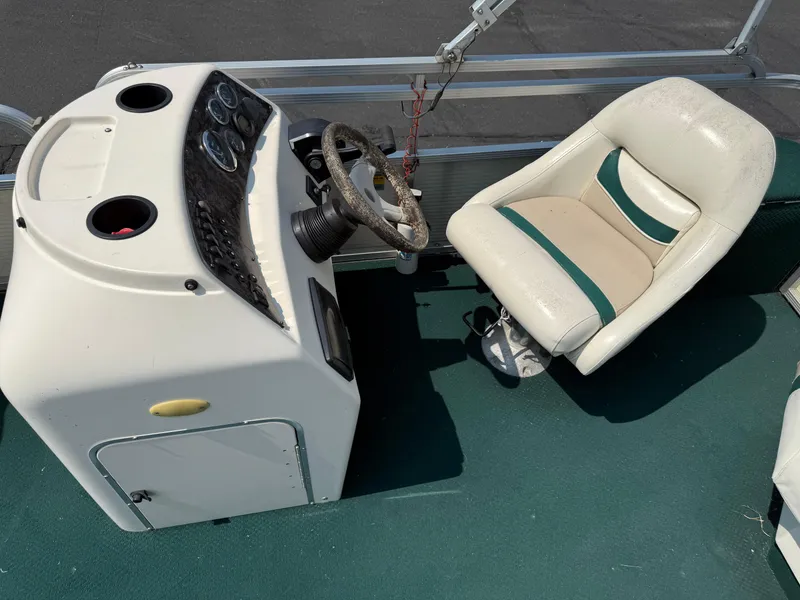 Slide: The Image of 1998 Bennington 22 boat cockpit with steering wheel and white captain's chair. - 11