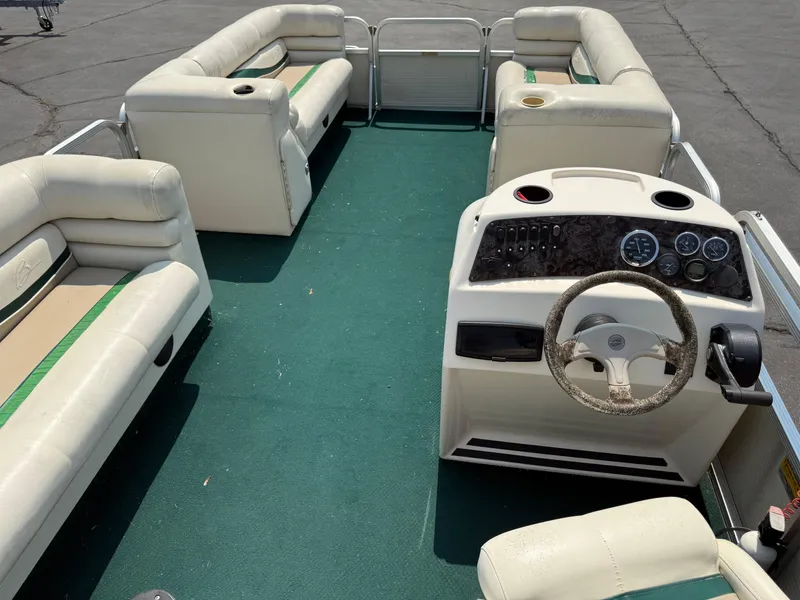 Slide: The Image of 1998 Bennington 22 pontoon boat interior with green carpet and white seating. - 13