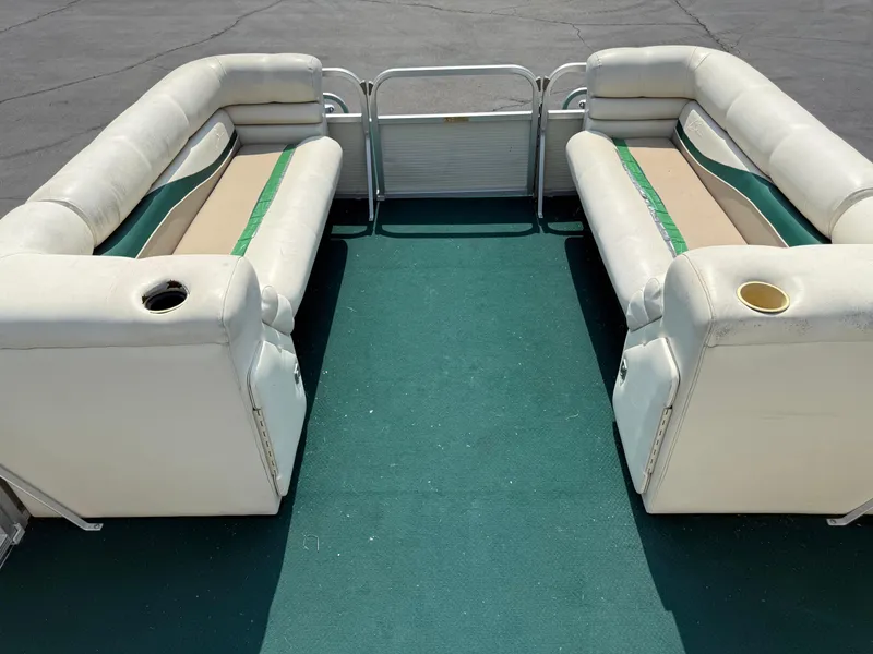 Slide: The Image of 1998 Bennington 22 pontoon boat interior with white seating and green carpet. - 15
