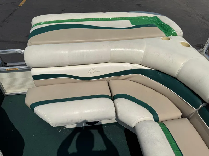 Slide: The Image of 1998 Bennington 22 boat seating with green and beige upholstery, featuring green tape repair. - 16
