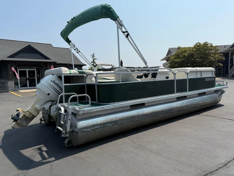 Slide: The Image of 1998 Bennington 22 pontoon boat with Johnson outboard motor, parked in a lot. - 3