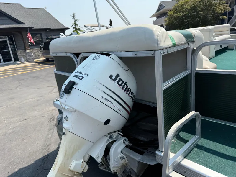 Slide: The Image of 1998 Bennington 22 boat with Johnson 40 outboard motor, docked near buildings. - 4