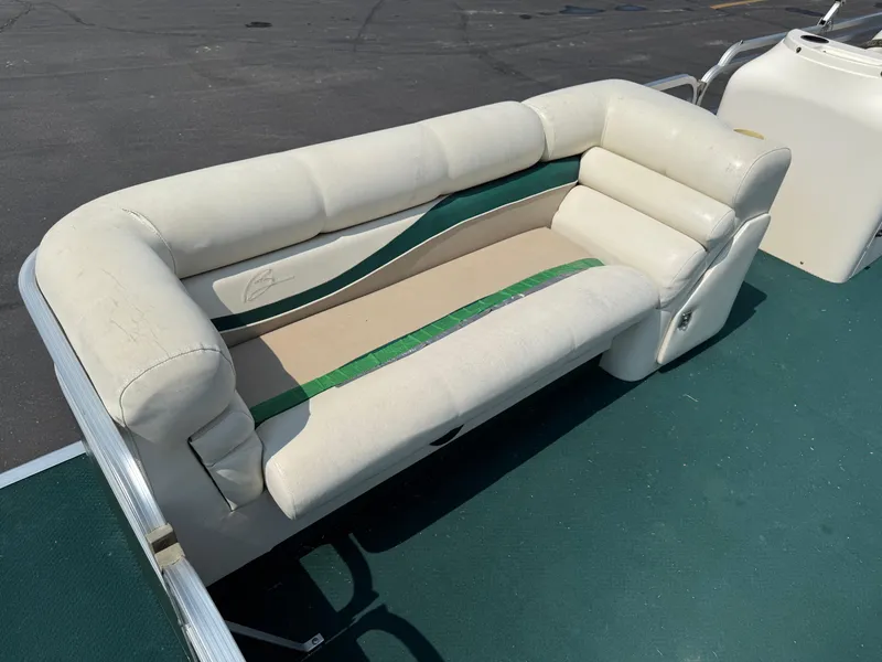 Slide: The Image of White seating on a 1998 Bennington 22 boat with green accents, docked on a sunny day. - 6