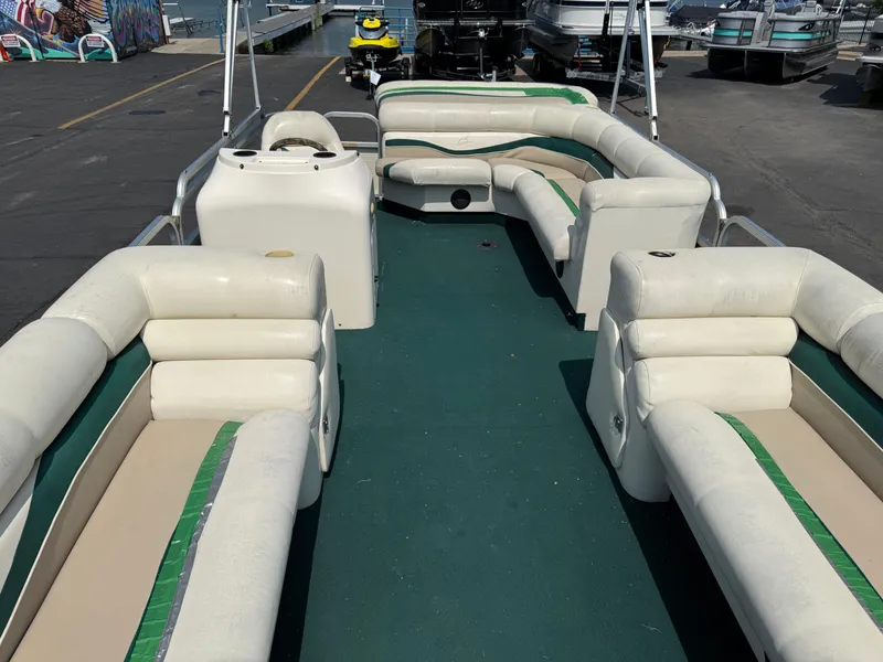 Slide: The Image of 1998 Bennington 22 pontoon boat with green carpet and white seating, docked at marina. - 8