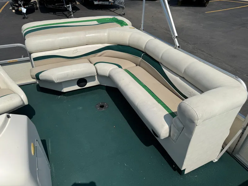Slide: The Image of 1998 Bennington 22 pontoon boat interior with white and green seating on a green carpet. - 9
