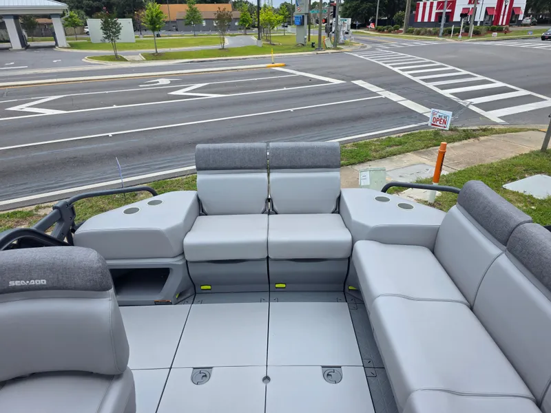 Slide: The Image of 2024 Sea-Doo Switch boat interior with gray seating, parked near a road intersection. - 9