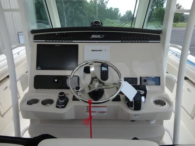 Slide: The Image of 2021 Boston Whaler 350 Outrage helm with steering wheel and navigation controls. - 10