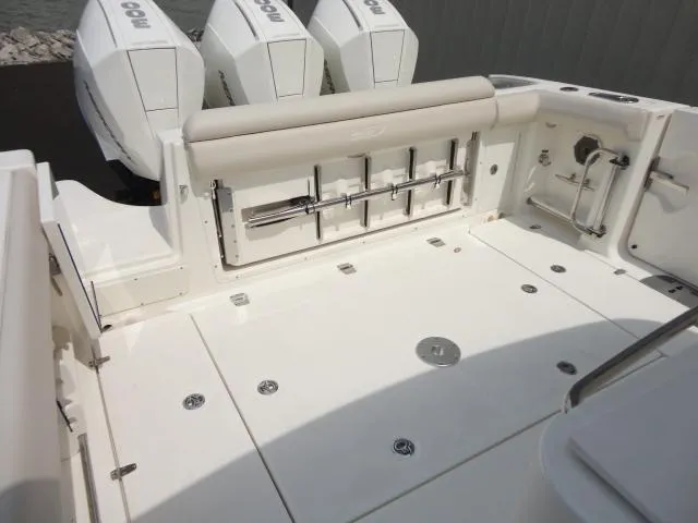 Slide: The Image of 2021 Boston Whaler 350 Outrage boat deck with triple engines and fishing rod holders. - 12