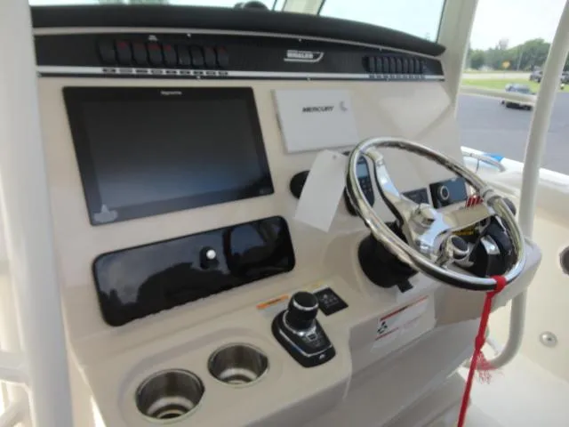 Slide: The Image of 2021 Boston Whaler 350 Outrage helm with steering wheel and navigation controls. - 14