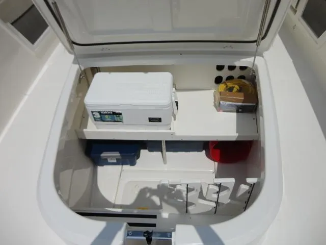 Slide: The Image of 2021 Boston Whaler 350 Outrage storage compartment with cooler and organized gear. - 19