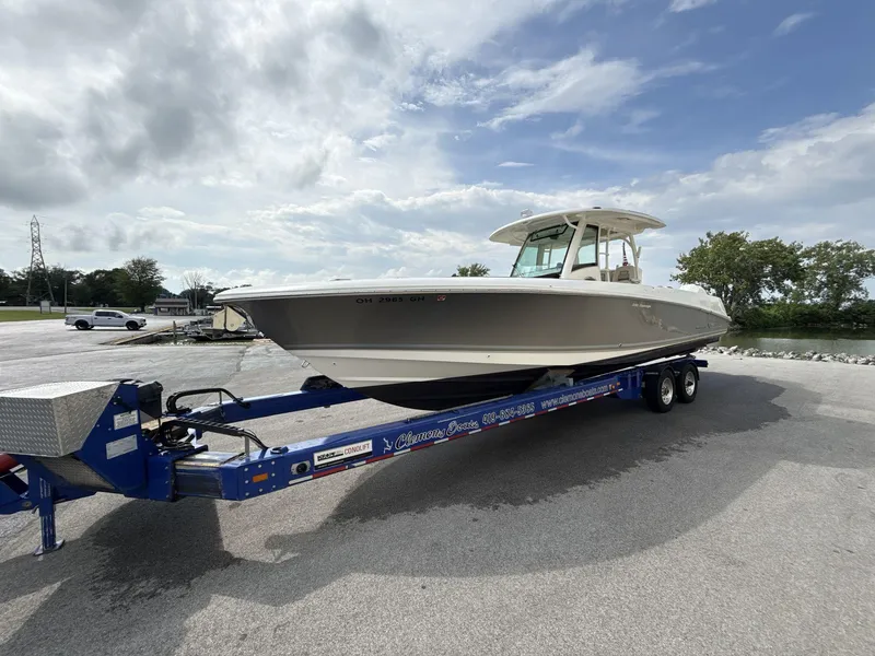 Slide: The Image of 2021 Boston Whaler 350 Outrage on trailer, parked outdoors under cloudy sky. - 4
