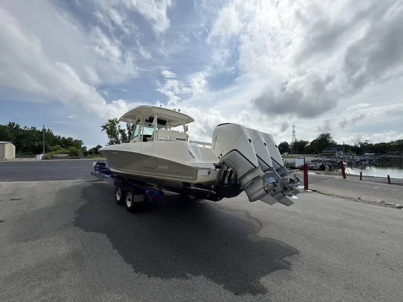 Slide: The Image of 2021 Boston Whaler 350 Outrage boat on trailer, parked near a marina. - 5