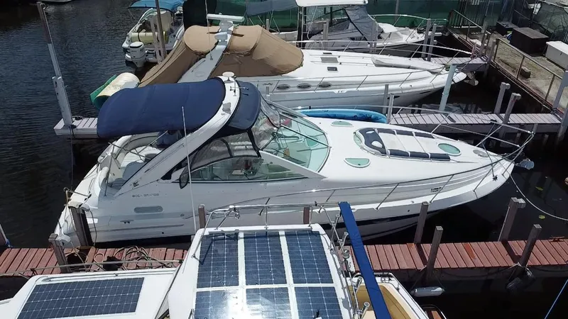 Slide: The Image of 2006 Doral 365 boat docked at marina, featuring blue canopy and sleek design. - 15