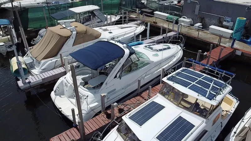Slide: The Image of Boats docked at marina, featuring a 2006 Doral 365 with blue canopy. - 18