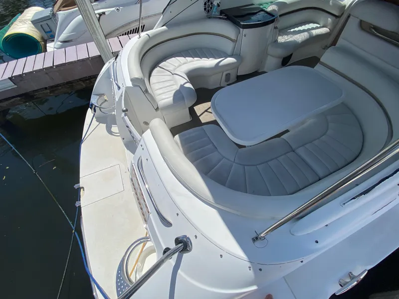 Slide: The Image of 2006 Doral 365 boat interior with white seating and table, docked by the water. - 24