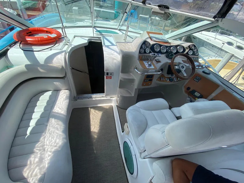 Slide: The Image of Interior of a 2006 Doral 365 boat with white seating and control panel. - 27
